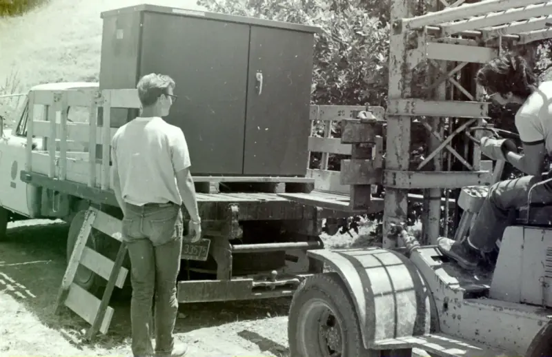 Historical photo of the transformer being loaded on the back of a truck.