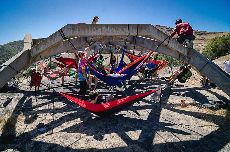 Students relaxing in colorful hammocks suspended inside the Poly Pavilion.