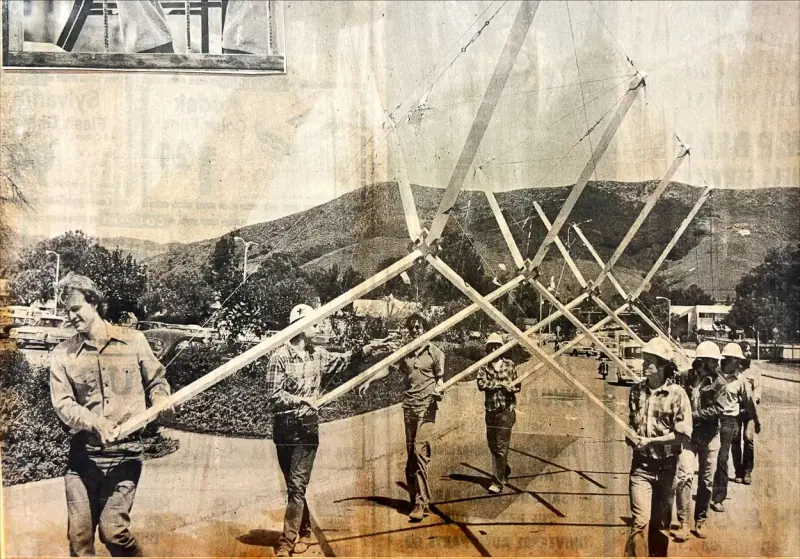 The student builders of the tensegrity mass carrying it out to the canyon during Design Village.