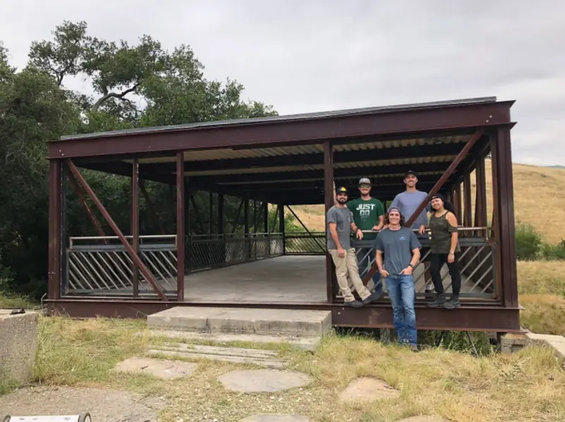 A group photo of students who restored the bridge house, adding railings and reopening the boarded-up windows.