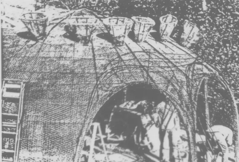 Construction photo showing the mesh outline and carved hillside.